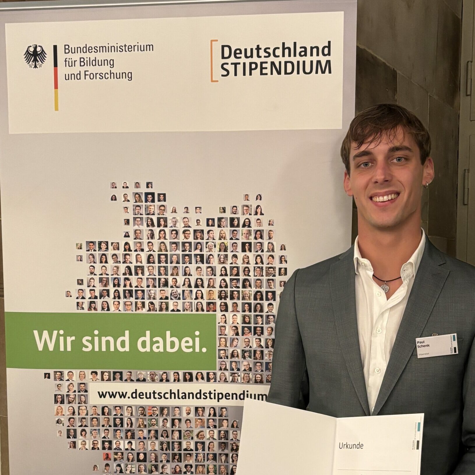 Paul Schenk erhält erneut das Deutschlandstipendium und präsentiert die Urkunde